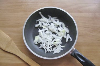 Soğanları soy, yıka ve ince ince doğra. Bir tavaya yerleştir.