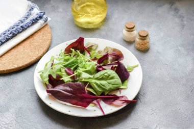 Düz bir salata tabağı al - yeşillik karışımını hazırla.