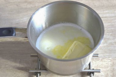 Hamuru hazırlamak için bir tencereye 125 ml dökün. Süt, 125 ml. Su, bir tutam tuz ve ısı ekle. Çözünene kadar tereyağını ısıtılmış karışıma koy.