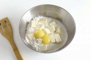 Unu, doğranmış yağı, tuzu, şekeri ve sarıları derin bir kasede birleştirin..