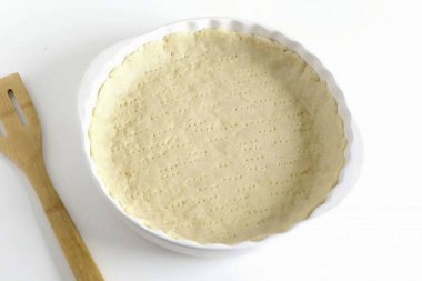 Hamuru iki eşit olmayan parçaya böl. Küçük parçayı sar ve şimdilik buzdolabına koy. İkinci kısmı çıkar ve güzelce yağlı bir forma geçir. İstenen boyuta getirmek için ellerinizi kullanın ve kenarlarını şekillendirin. Çubuğu tak.