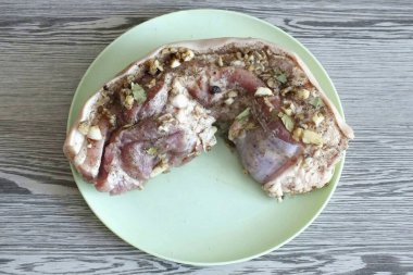 Domuz etini bıçakla birkaç yerden delin. Tuz ve baharatla ovala..