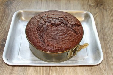 Çapı 22 santimetre olan sökülebilir bir kalıbı bitkisel yağla ve üzerine un serp. Altına kağıt bir daire çiz ve hamuru dök. Hava kabarcıklarını kaldırmak için masaya birkaç kez hafifçe vurun. Sıcak fırına koy.