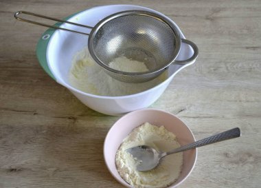 Yumurta kütlesine kabartma tozu ile ayıklanmış un ekle, küçük porsiyonlar ekle, pürüzsüz olana kadar her parçayı yavaşça karıştır.