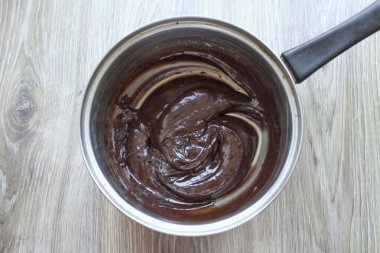 Kremayı kaynat, ama kaynatma. Sıcaktan kurtul ve kırık çikolata ekle. Yumuşak ve serin oda sıcaklığına kadar karıştırın.