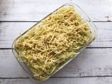 Her şeyi rendelenmiş peynirle serp ve önceden ısıtılmış fırına 15-20 dakika boyunca 180 dereceye yerleştir..