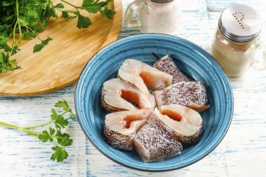 Kafasını, yüzgeçlerini ve kuyruğunu kes, balığı parçalara ayır ve derin bir konteynıra koy..