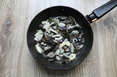 Kırpılmış mantar ekleyin ve her şeyi 8 dakika boyunca orta sıcaklıkta sotelendirin.