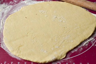 Kalkmış hamuru elinizle sarın, silikon bir paspasa koyun ve 1 cm kalınlığında olmayan bir katmana merdaneyle sarın..