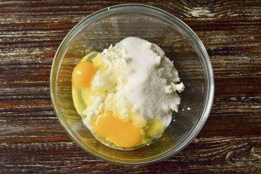 Süzme peyniri bir kaseye koy, tavuk yumurtasına çırp, şeker ekle..