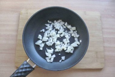 Soğanları soy, yıka ve doğra. Bir tavaya yerleştir.