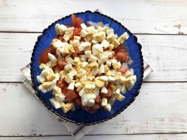 Haşlanmış yumurtaları soy, küçük küplere böl ve diğer malzemelere ekle..