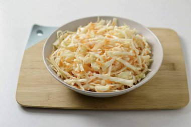 Lahanayı tuzla, az da olsa ellerinle hatırla ki lahana yumuşasın. Sonra havuçları ekle ve karıştır..