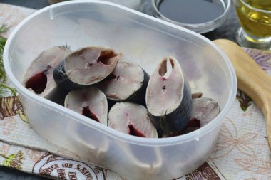 Ringaların buzlarını çözün, kabuklarını soyun ve kafasını kesin. Balığı küçük parçalara ayır ve bir turşu kabına koy..