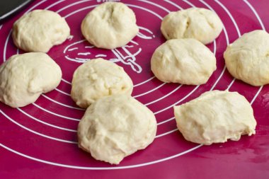 Yükselen hamuru masaya koy ve hemen eşit büyüklükte parçalara böl..