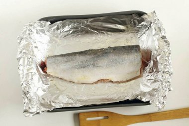 Balığı temizle. İç organlarını, başını, kuyruğunu ve yüzgeçlerini kes. Sonra leşi akan suyun altında durula, kurula, tuz ve karabiberle ovala. Balığı yağla fırçala (bir çay kaşığı bunun için yeterli) ve sıkılmış meyve suyuyla karıştır.