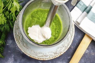 Bezelyeleri saflaştır, biraz da et suyu ekle. Köpüğün sulanmasını önlemek için çok fazla sıvı eklemeyin. Sonra ekşi krema ekleyin. Yağ içerikli veya yoğun krema. Tekrar aç.