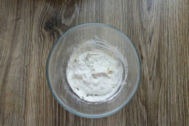 Ekşi krema, tuz, biber ve kuru otları bir kaseye koy. Her şeyi iyice karıştır..