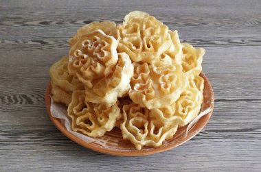 Bitmiş kurabiyeleri peçetelerle kaplı bir tabağa aktar. Arzu ediyorsan pudra şekeri serp.