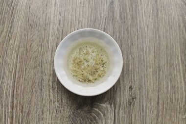 Bir kasede rendelenmiş sarımsak, tuz, biber ve limon suyunu karıştır. Sebze yağı ekle ve iyice karıştır..