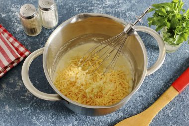 Her şeyi karıştır ve ince rendelenmiş peynir ekle.