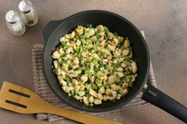 Doğranmış yeşil soğan ekle, karıştır, ısıdan kaldır ve dolguyu hafifçe soğut..