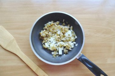 Turşuyu ya da salatalık turşusunu ince ince doğra ve tavaya koy. Soğanları soy, yıka ve ince ince doğra. Salatalığa ekle.