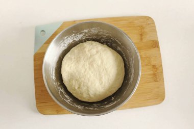 Önce, her şeyi çatal ya da kaşıkla karıştır, sonra her şeyi masaya koy ve bütün un emilene kadar hamuru ellerinle yoğur. Hamur eline biraz yapışmalı, ama aldırma. Mangırı topla, topla. 