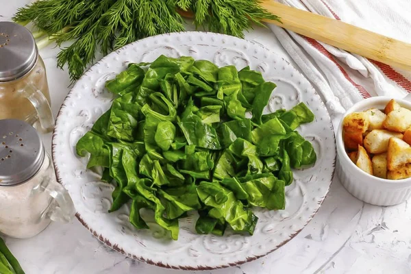 ほうれん草の束を取り出し 両側に葉をすすいでください 茎を切り 余分な水分を除去するためにペーパータオルで軽く葉を乾燥させます — ストック写真