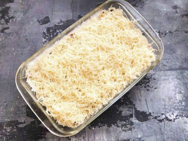 Fırına dayanıklı bir tabak al ve içine sosis ve soğan koy, üzerine rendelenmiş peynir serp ve önceden ısıtılmış fırını 15-20 dakika boyunca 180 dereceye gönder..