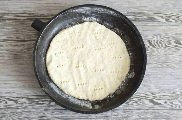 小麦粉の表面の各部分からケーキをロールアウト 小麦粉で鍋やフライパンを軽くほこり 地殻をレイアウト 泡がベーキング中に形成するのを防ぐためにフォークでそれをピアス 25分間180度に予熱したオーブンに入れてください — ストック写真