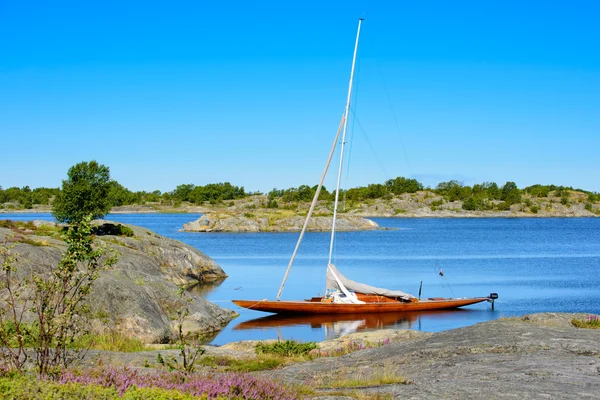 Wooden sailboat in natural harbour — Stock Photo, Image