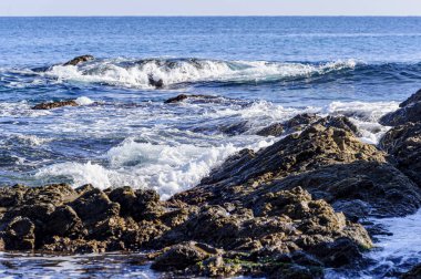 _ JP83974-Akdeniz kıyısı - Fransa 'nın güneyinde Akdeniz kıyısı. Esterel 'in kırmızı kayaları denize iner. Kayaların üzerinde dalgalar beyaz köpüğe neden olur..