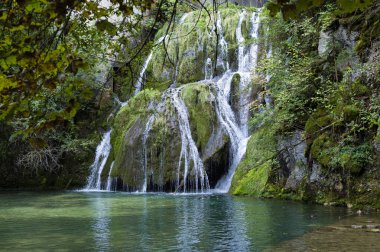 Fransa 'daki Jura Dağları' ndaki ormanın ortasında muhteşem bir şelale. Bu bölgede, karistik arazi temiz ve soğuk suyla güzel şelalelere olanak sağlar..