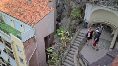 Nice, Fransa - 18 Ağustos 2020: 8K Turistler Fransız Rivierası, Fransa, Avrupa 'daki Castle Park' taki Bellanda Kulesi 'nin manzarasına erişmek için merdivenlerden inip çıkıyorlar - 8K UHD (7680 x 4320)