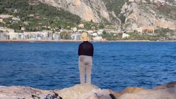 Vecchia donna che pesca a Mentone, Francia. Vista posteriore — Video Stock