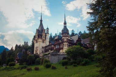 Dağlarda güzel bir kale. Orman arka planındaki saray. Kuleleri olan Avrupa kalesi.