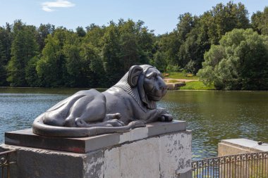 Mısırlı sfenks, Moskova 'daki Kuzminsky Parkı' nın arka planında bir aslanın dökme demir heykelini şekillendirdi.