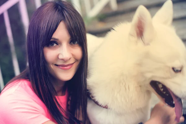 Mädchen sitzt auf der Treppe und spielt mit ihrem Husky-Hund — Stockfoto