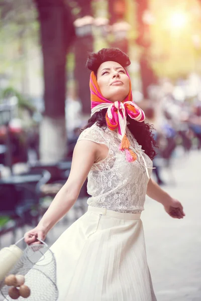 Mujer dando vueltas en la calle con una lata y cesta con huevos . — Foto de Stock