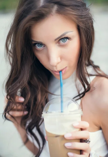 Menina bonita feliz sentada nas escadas no parque e beber café gelado — Fotografia de Stock