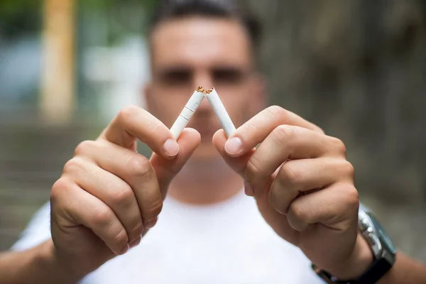 Jovem atraente homem quebrando cigarro — Fotografia de Stock