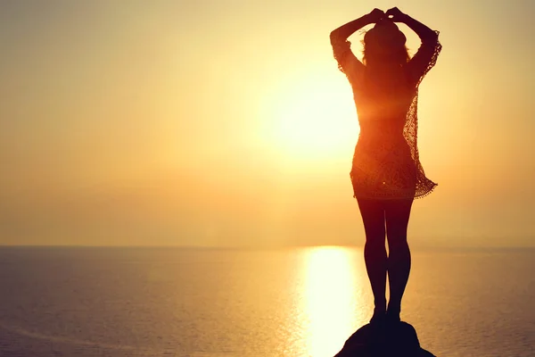 Mulher fazendo figura de ioga na praia ao pôr do sol — Fotografia de Stock