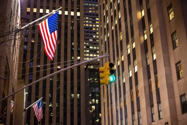 Светофоры Нью-Йорка и американские флаги с небоскребами на заднем плане — стоковое фото