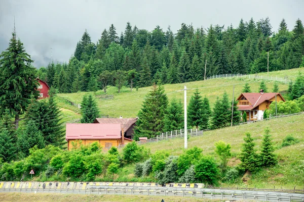 Casa de montanha de madeira tradicional no campo verde no verão — Fotografia de Stock