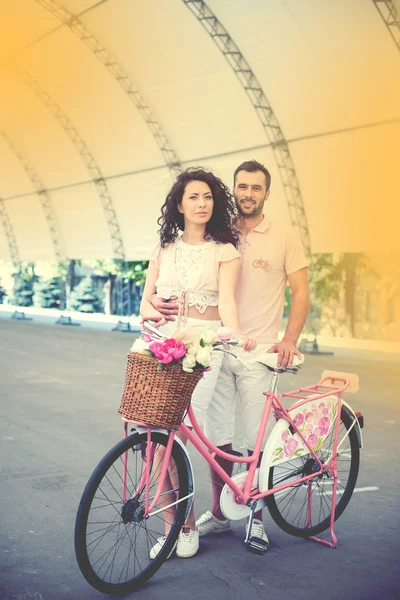 Couple with pink vintage bicycle in the summer park — Stock Photo, Image
