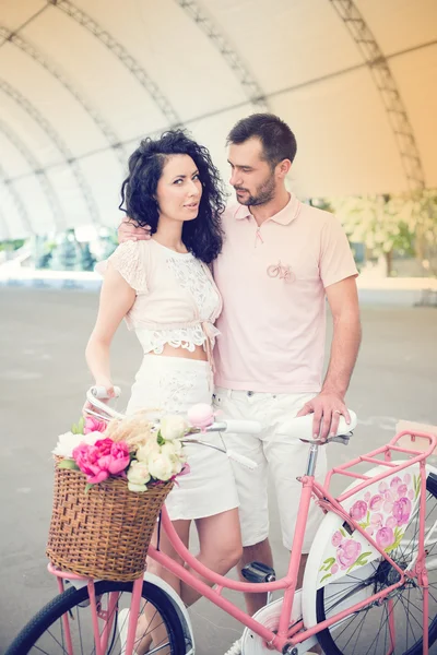 Couple with pink vintage bicycle in the summer park — Stock Photo, Image