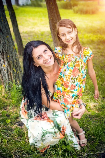 Entzückende Mutter mit ihrer Tochter im Garten — Stockfoto