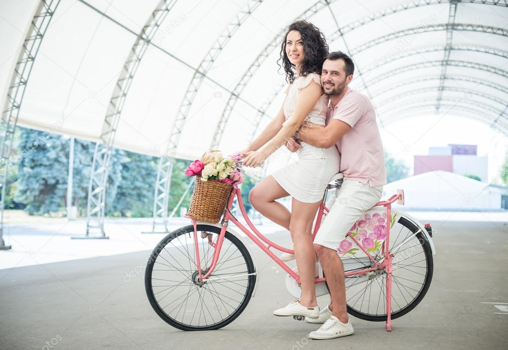 Couple with pink vintage bicycle in the summer park