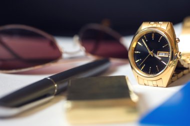 Erkek Aksesuar, pasaport, kalem, altın saat, güneş gözlüğü ve hafif beyaz arka plan üzerinde. Seçici odak.